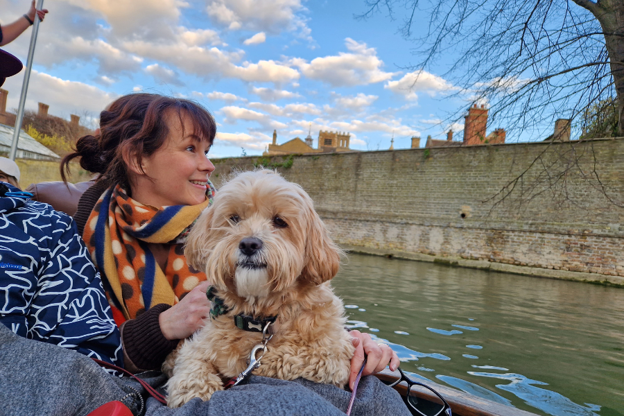 Dog and lady sitting on a punting tour in Cambridge along the River Cam
