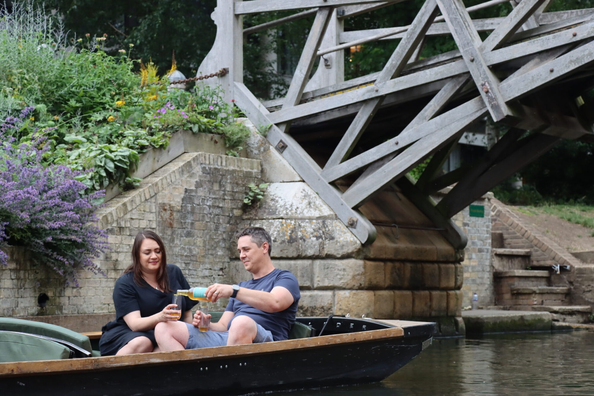 couple punting in Cambridge pouring a glass of alcohol